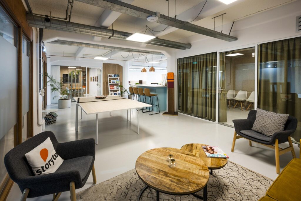 Modern office interior on Van Diemenstraat with a lounge area, meeting rooms, and a bar-style workspace.
